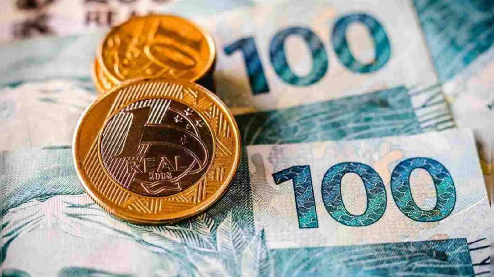 Notas de cem e moedas de dez e um real