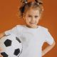 Menina segurando uma bola de futebol
