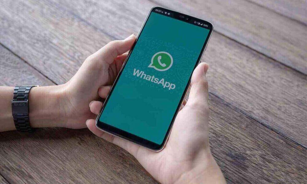 Mãos segurando o celular com a tela aberta no Aplicativo WhatsApp