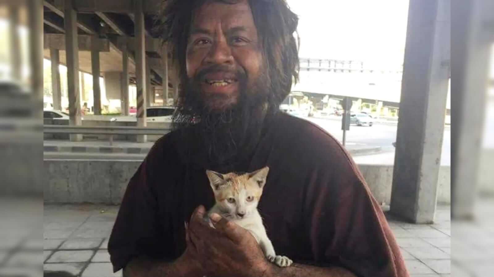 Homem sem-teto segurando gatinho