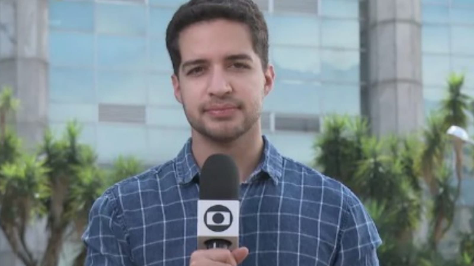 Jornalista Gabriel Luiz com microfone da TV Globo