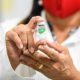 Mulher segurando ampola de vacina contra gripe