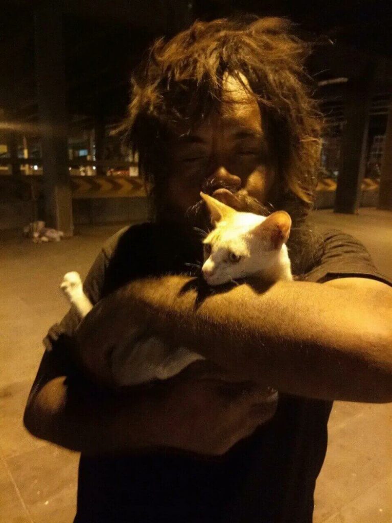 Homem sem-teto segurando gatinho