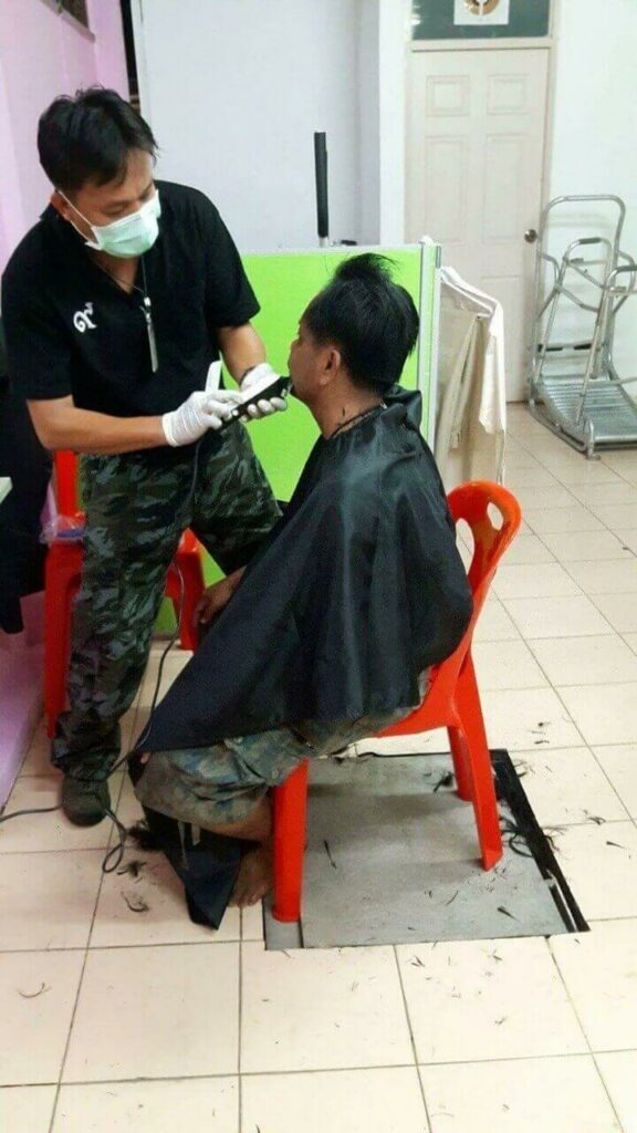 Cabeleireiro cortando cabelo de homem sem-teto