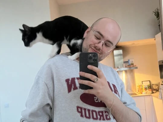Homem e gato preto e branco no ombro