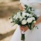 Noiva segurando um buquê de rosas brancas
