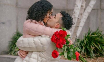 Namorados se beijando com buquê de rosas