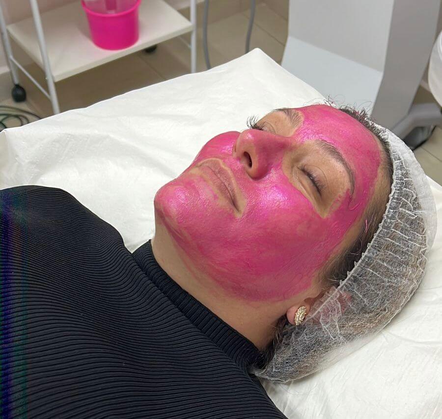 Mulher com máscara facial rosa