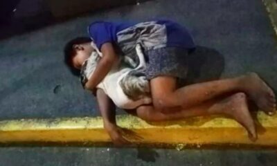 Foto de menino dormindo na rua abraçado com seu cachorrinho