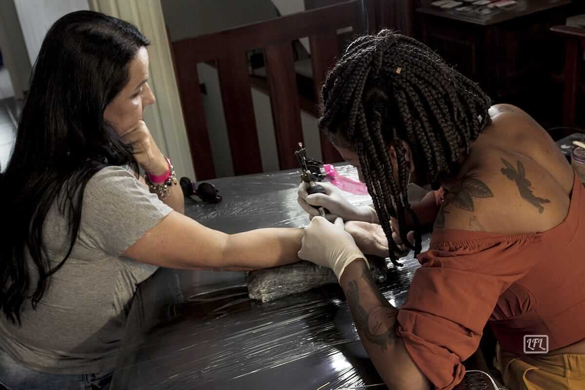 Mulher fazendo tatuagem