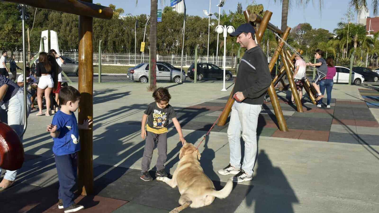 Criança cumprimentando cachorro em parque de Jundiaí