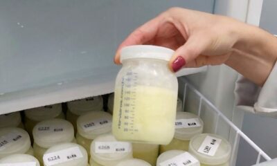 Mão segurando frasco de leite