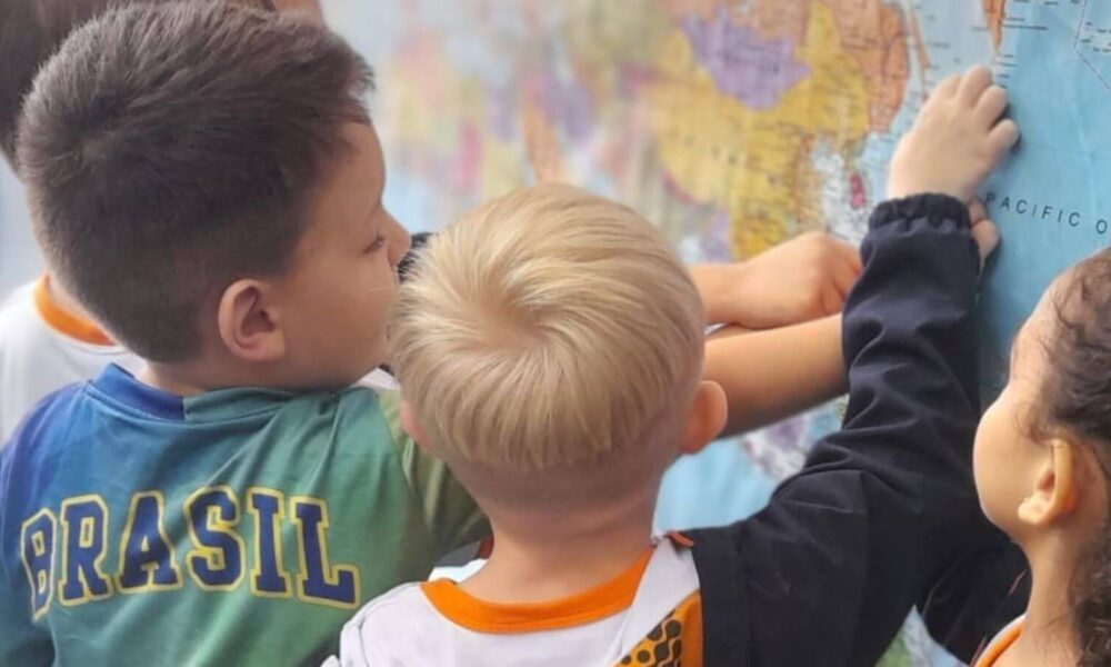 Crianças apontando para mapa