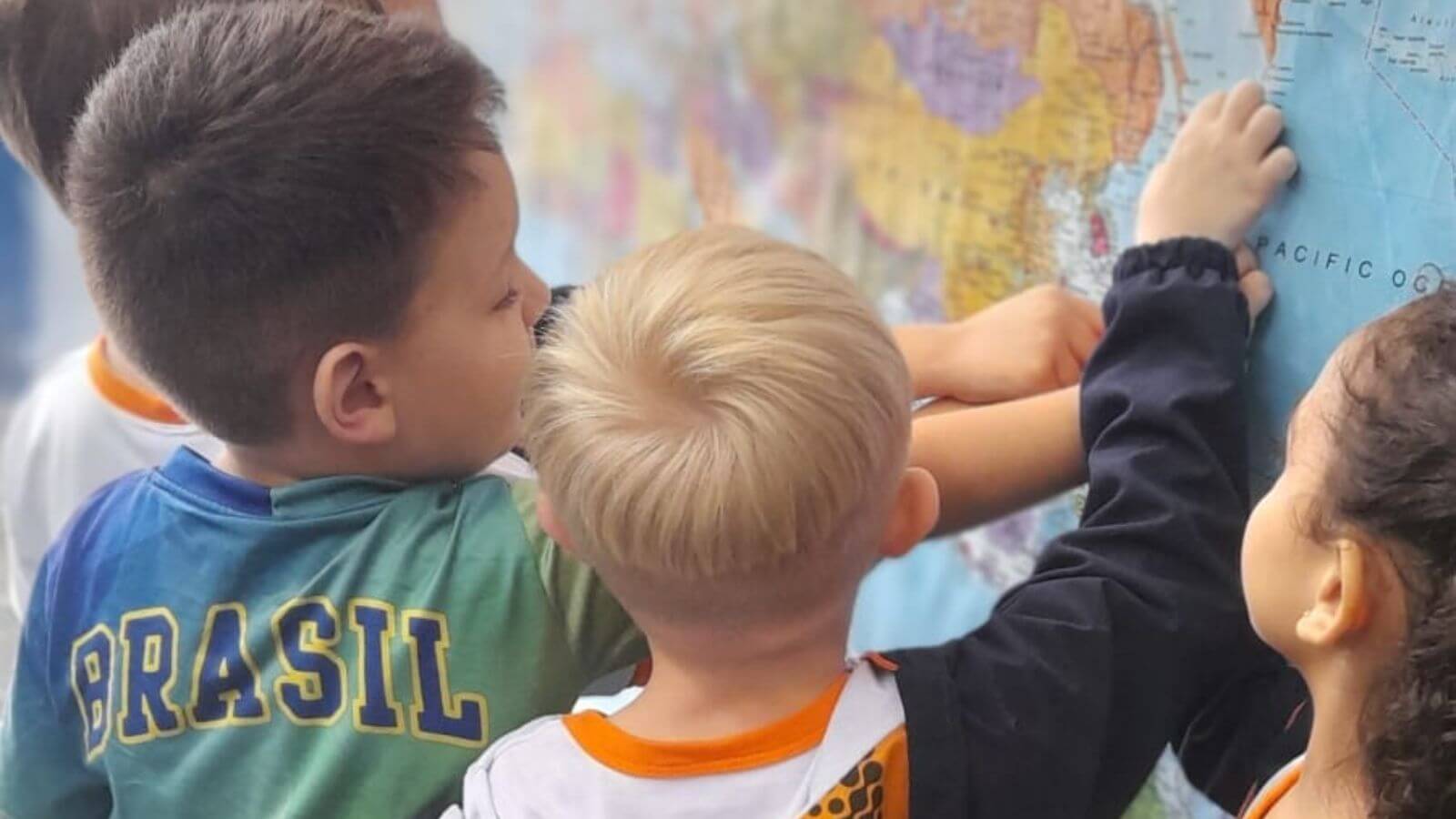 Crianças apontando para mapa