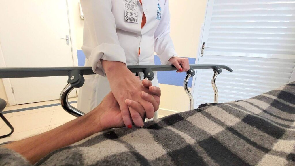 Assistente Social segurando mão de paciente