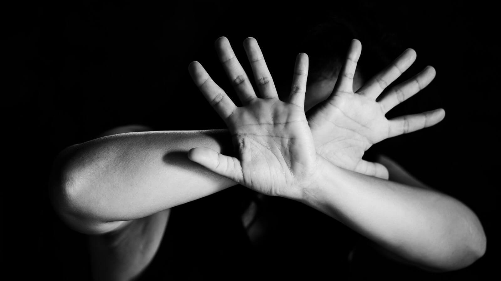 Mulher vítima de violência se protegendo com os braços