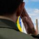 Militar batendo continência à bandeira do Brasil