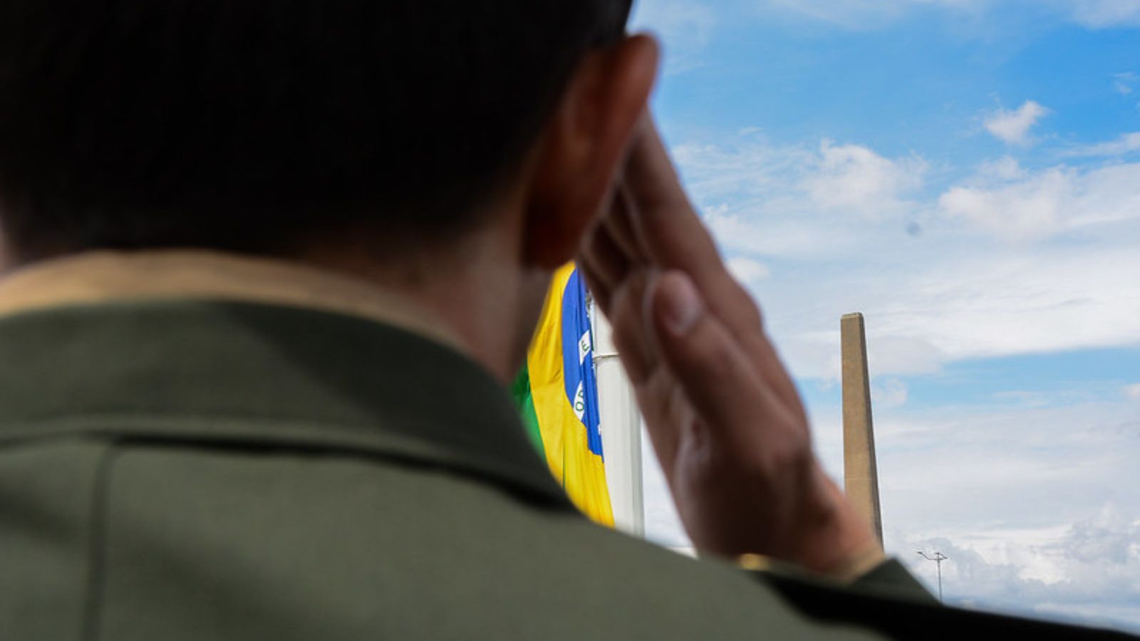 Militar batendo continência à bandeira do Brasil