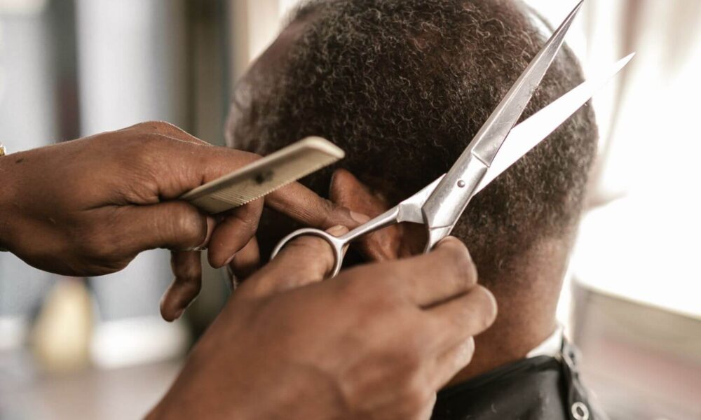 Homem cortando cabelo de outro homem