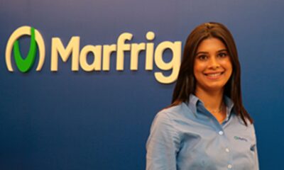 Mulher de camisa azul em frente a letreiro da empresa Marfrig, em Itupeva