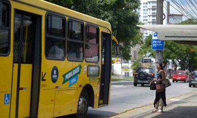 Mulher em calçada e ônibus municipal de Jundiaí na rua