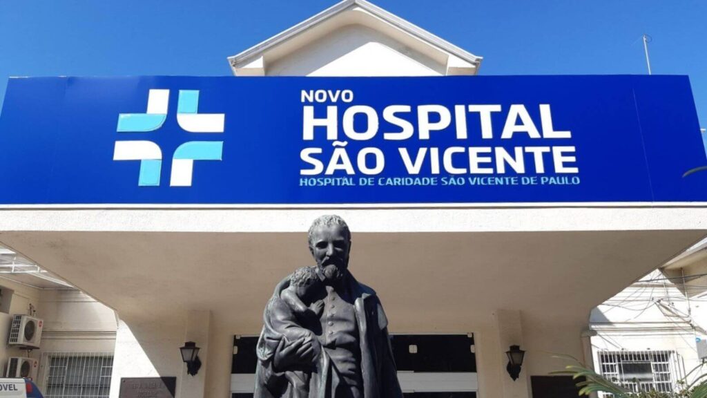 Entrada do Novo Hospital São Vicente, em Jundiaí, com estátua de São Vicente de Paulo em destaque e placa ao fundo.
