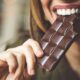 mulher comendo uma barra de chocolate