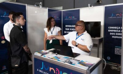 Um homem e uma mulher em stand da Prefeitura de Jundiaí durante evento de logística Brasil Log conversando com outro rapaz