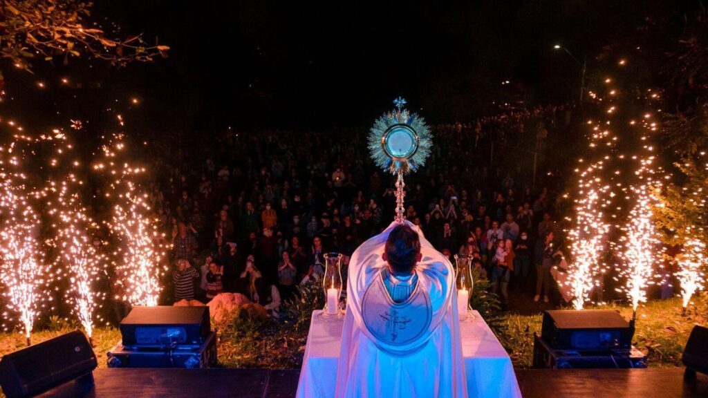 Adoração ao Santíssimo Sacramento em Jundiaí com fogos de artifício e grande número de fiéis à noite.