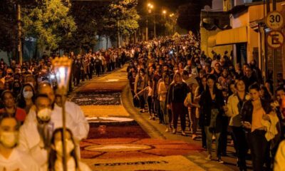 Procissão de Corpus Christi em Jundiaí com tapetes coloridos e grande número de fiéis, à noite.