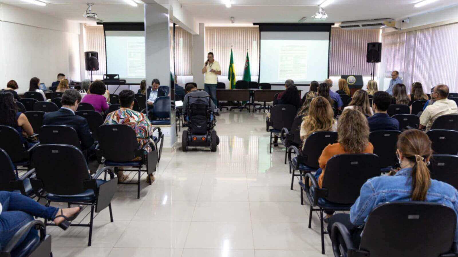 Uma palestra sobre a contratação de pessoas com deficiência, com diversas pessoas presentes em um auditório em Jundiaí