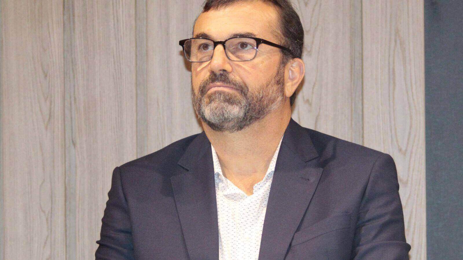 Marcelo Cereser, diretor do CIESP Jundiaí, durante evento oficial, vestindo um terno escuro e camisa clara, expressando seriedade.