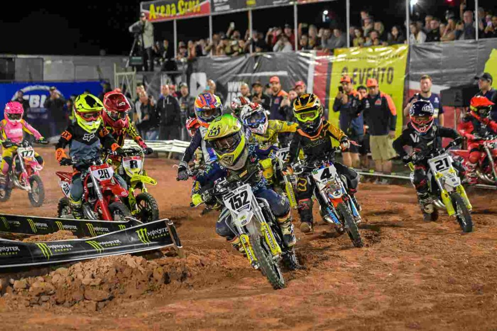 Competição de motocross na Jundiaí Arena Cross, com diversos pilotos em motocicletas de diferentes equipes, disputando em pista de terra.