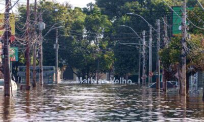 Rua alagada com árvores ao fundo e uma placa com o nome do bairro Matias Velho, do Rio Grande do Sul