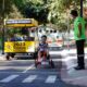Criança andando de kart no Jardim da Mobilidade em Jundiaí, supervisionada por um instrutor. Atividade do Maio Amarelo