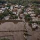 Bairro alagado após enchente, mostrando casas inundadas e danos causados pela água em uma comunidade do Rio Grande do Sul.