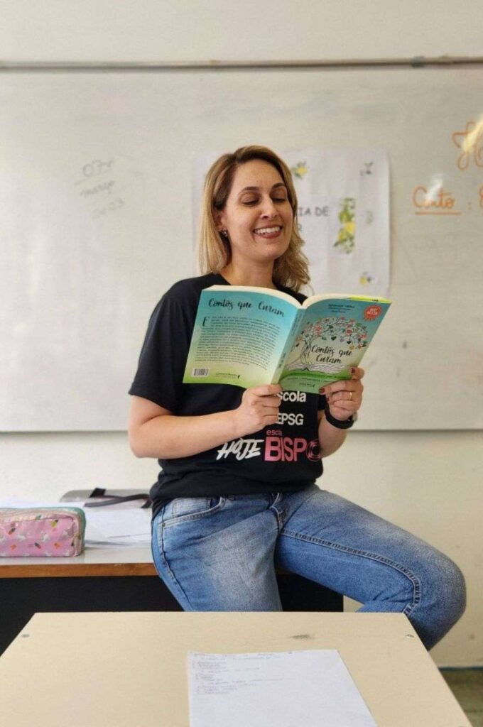 A professora Vanessa Bonassa lendo um livro em sala de aula