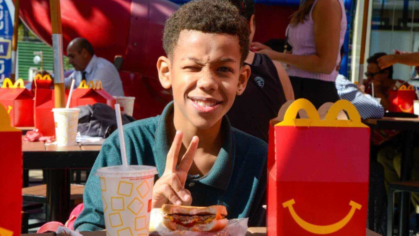 Menino em mesa do McDonald's de Jundiaí, participando do programa Mc Tour