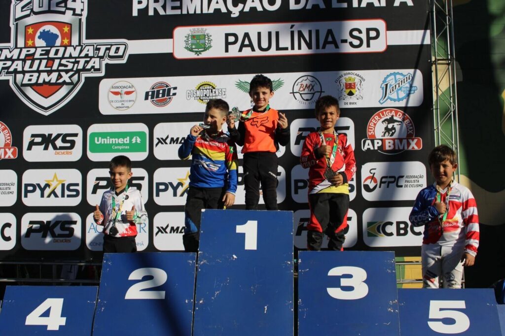 Atletas de BMX com medalhas em pódio de campeonato paulista do esporte