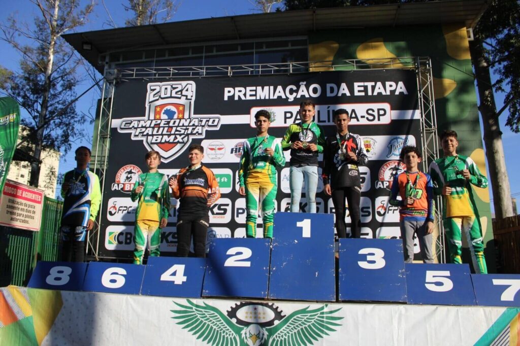 Atletas de BMX com medalhas em pódio de campeonato paulista do esporte