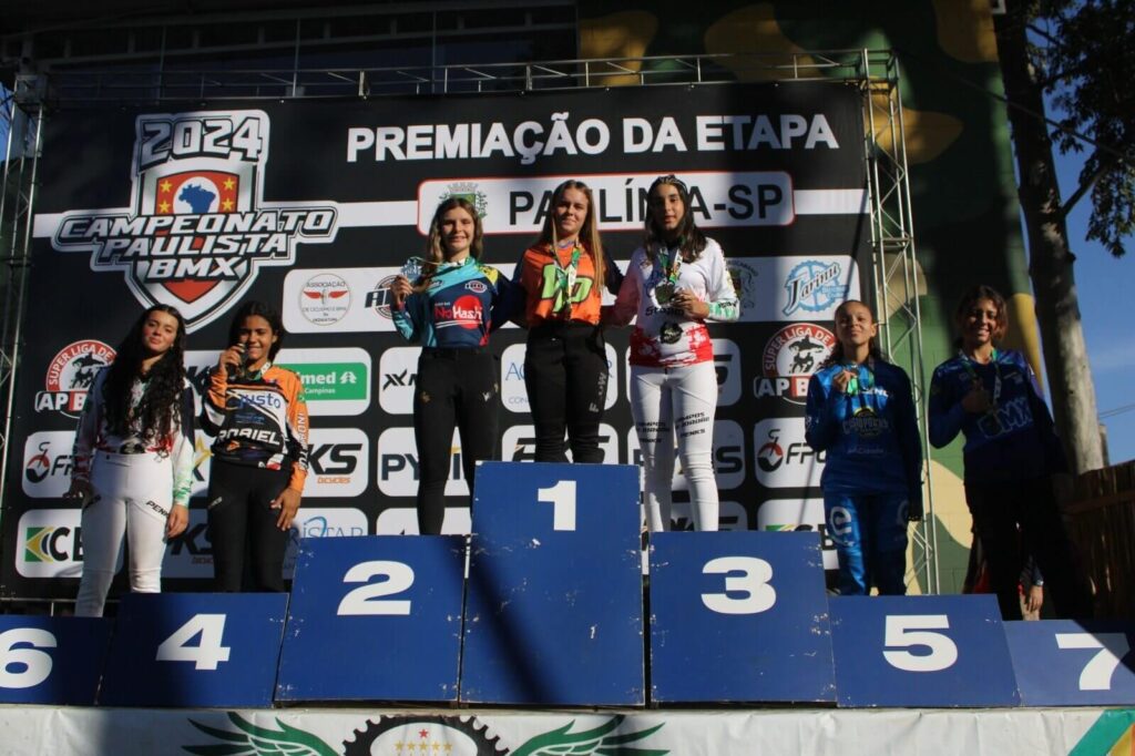 Atletas de BMX com medalhas em pódio de campeonato paulista do esporte