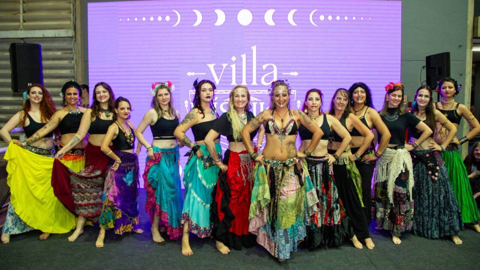 Dançarinas em frente a painel do evento Villa Mistika em Jundiaí