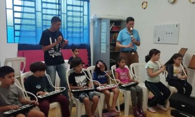 Crianças tocando instrumentos musicais em aula de música
