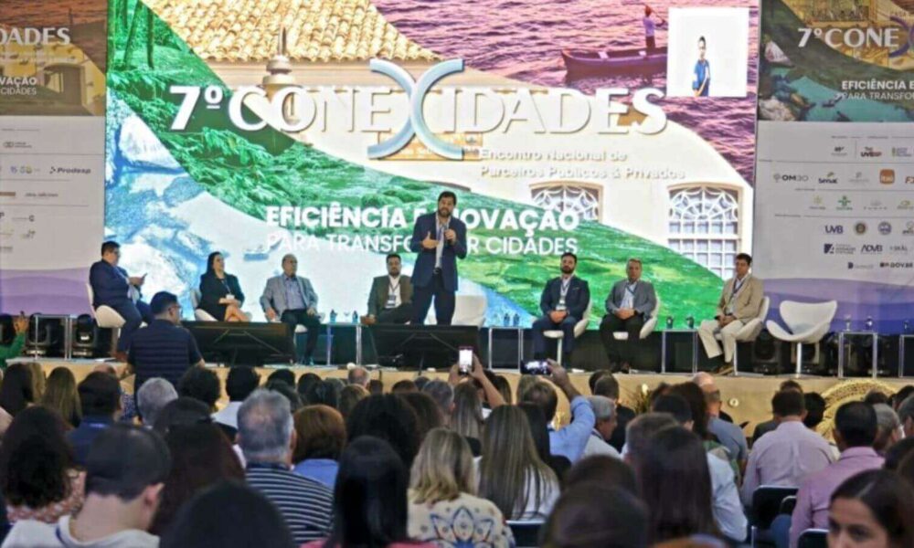 Evento do 7º Conexidades 2024, com uma grande plateia assistindo a uma apresentação no palco do prefeito de Jundiaí.