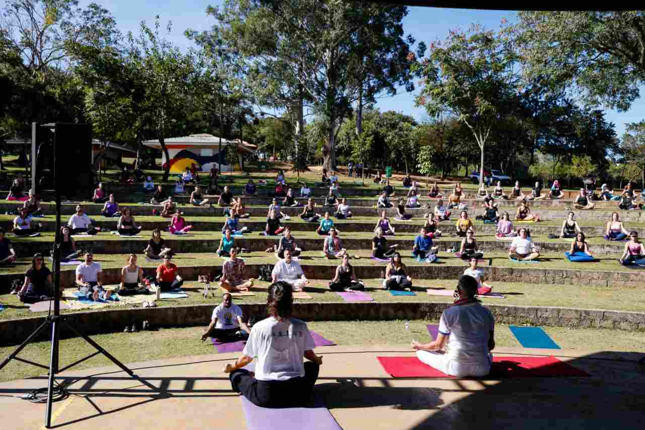 aula de yoga em Jundiaí no Parque da Cidade, com dezenas de praticantes ao ar livre em um anfiteatro.