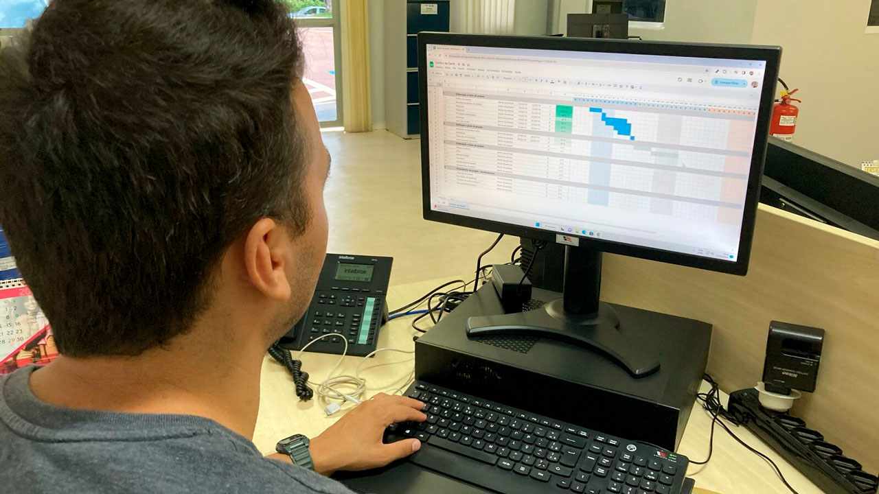 Homem usando computador no escritório, visualizando planilha de cursos gratuitos em Jundiaí oferecidos pelo Funss e Senai.