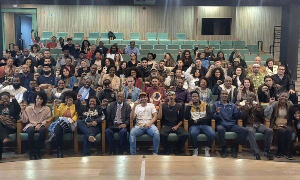 Participantes do Fórum de Promoção da Igualdade Racial em Jundiaí posam para foto em auditório.