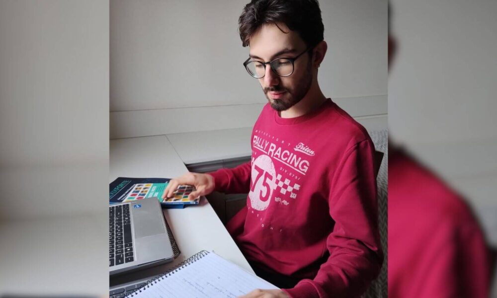 Jovem de Jundiaí estuda com livros e laptop.