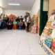 Grupo de pessoas, homens e mulheres, posando em uma sala, uma nova biblioteca comunitária