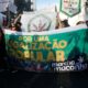 Manifestantes na Marcha da Maconha, segurando cartaz pedindo a legalização desta droga